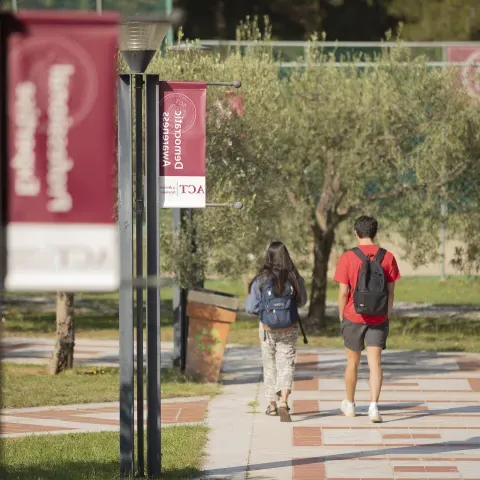 Students walk along a path at the American College of Thessaloniki in Greece